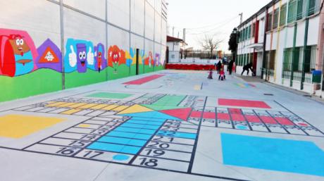 Padres y alumnos del colegio de Tinajas decoran el patio pintando en el suelo juegos tradicionales