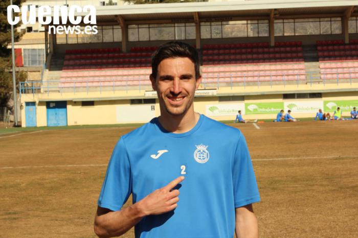 Oriol Dot posando mientras señala el escudo de la UB Conquense