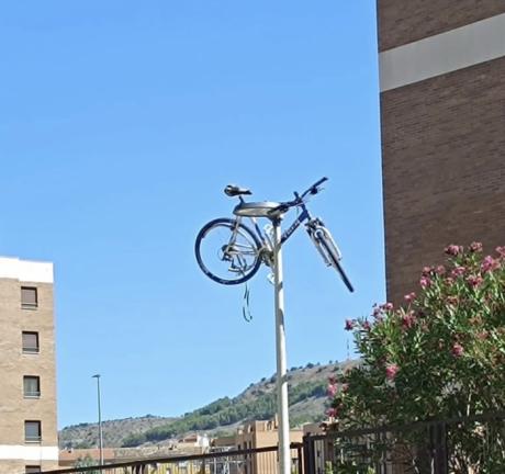 La Policía Local de Cuenca retira una bicicleta colgada de una farola antes de que caiga sobre los viandantes