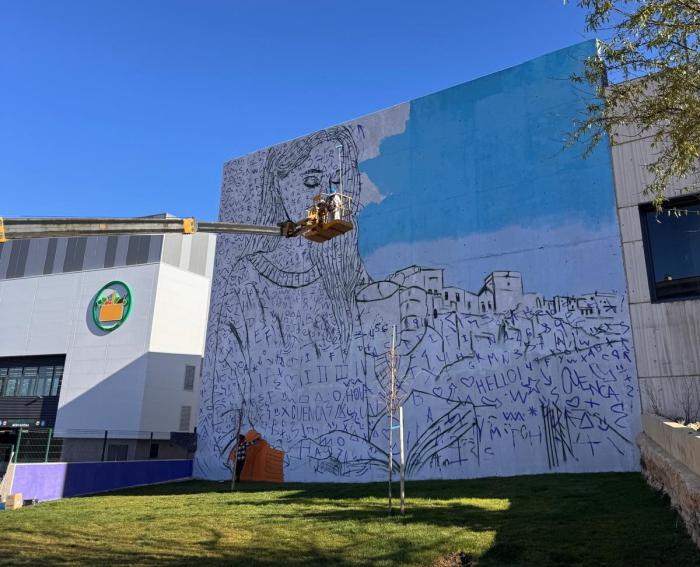 Los artistas Crisdose y Xolaka trabajan en el mural que transformará la fachada de la Delegación Provincial de Hacienda y GEACAM en Cuenca.