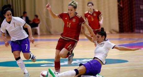 Anita Luján, jugadora de la Selección española conduce el balón ante dos rivales