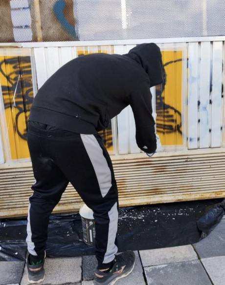 Un joven repara los daños de una de sus pintadas en Cuenca